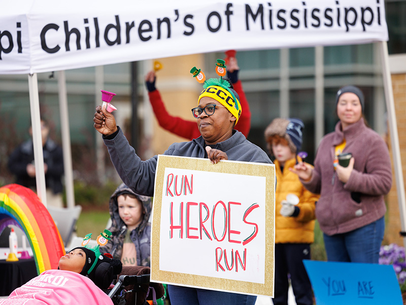 Nikita Roberts of Jackson and daughter Lundyn, left, cheer on competitors in Run the Rainbow for Children's.